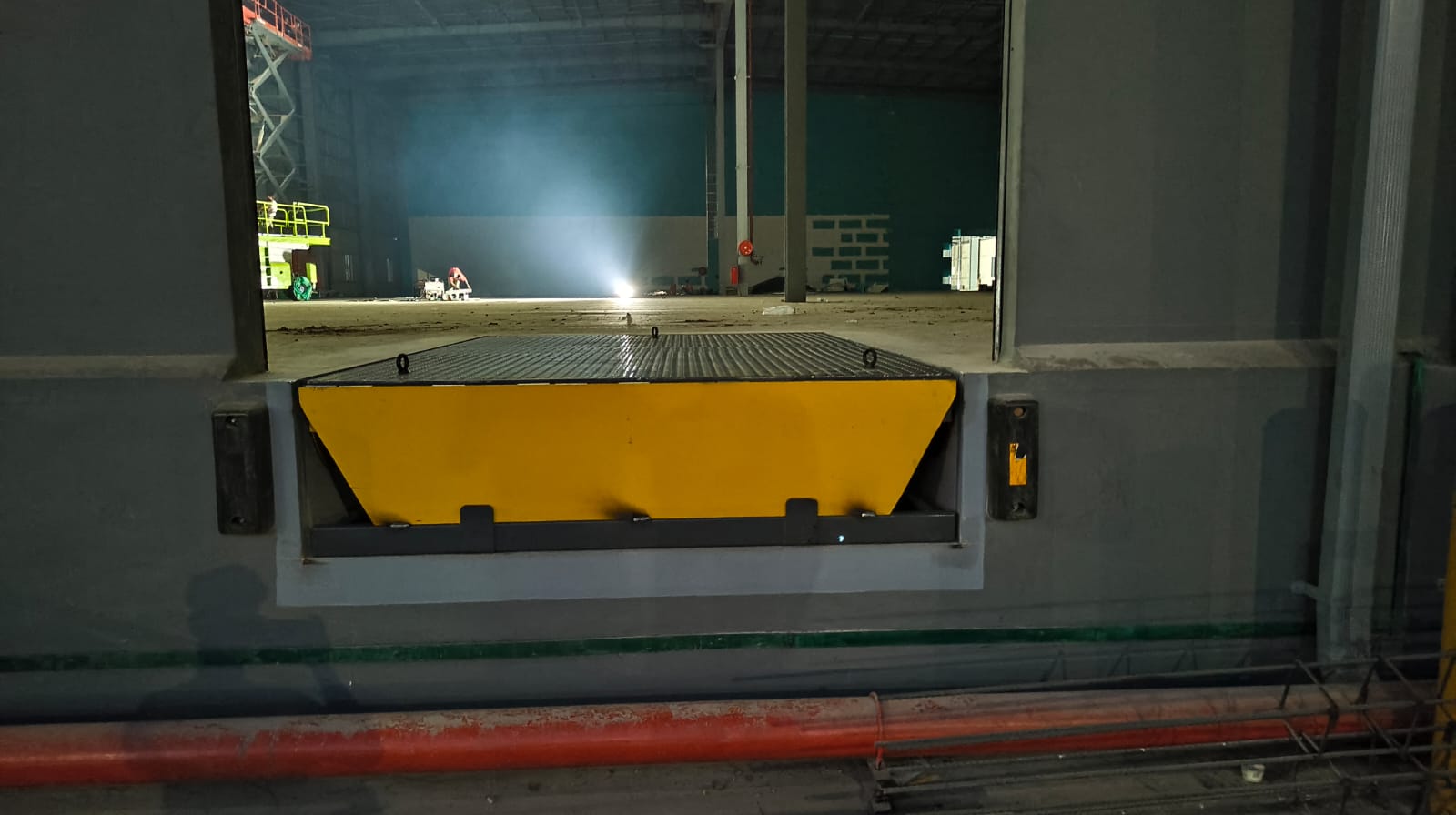 Dock leveller with dock bumpers installed at night