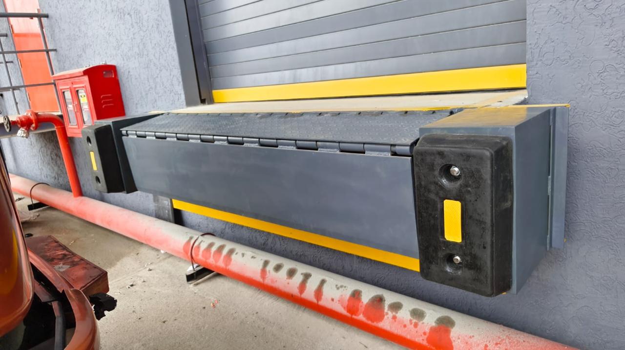 Angled view of an edge dock leveller with dock bumpers